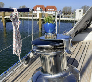 Sehr kleiner Blumentopf auf einer Winsche einer Segelyacht. Ein kleines Detail während einer Schiffsüberführung in die Ostsee.